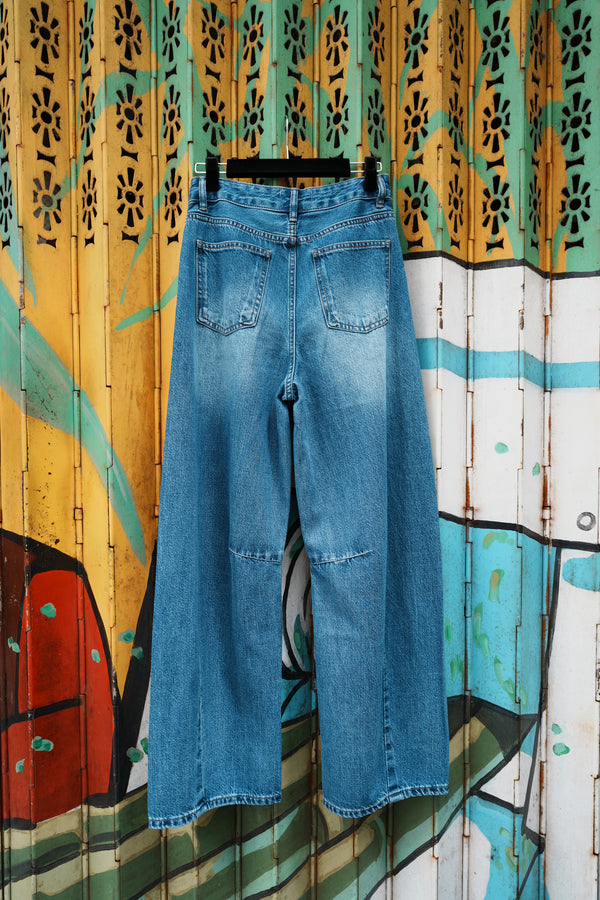 Folded blue jeans on a colorful wooden surface