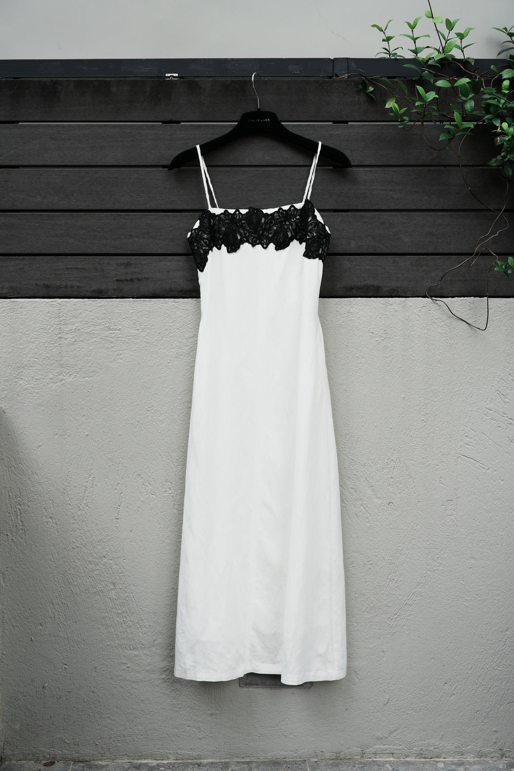 White dress with black lace on a beige background