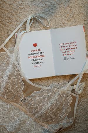 Book with inspirational quote on a lace bralette