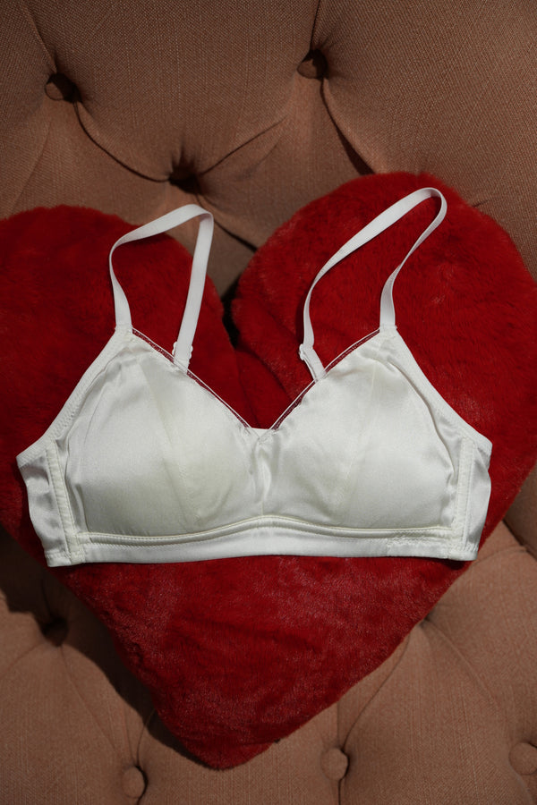 White bra on a red pillow with a brown cushion background