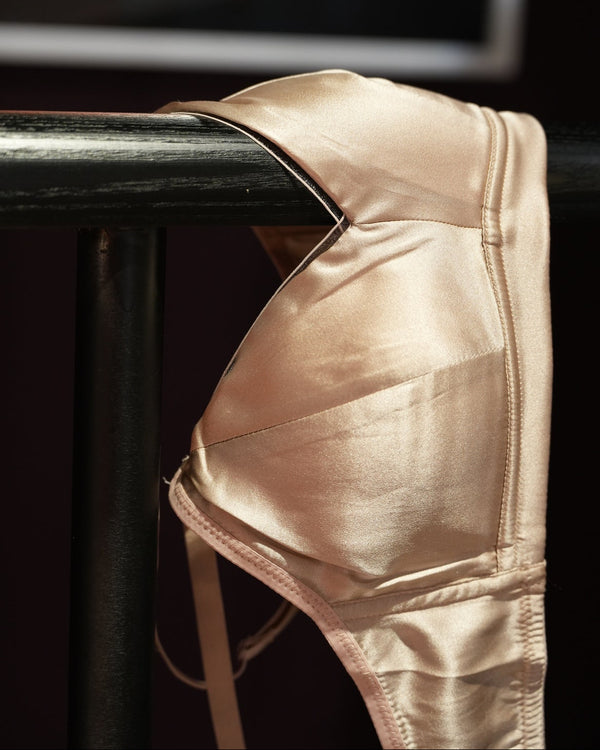 Beige underwear on a black chair with a blurred background