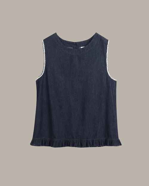 A sleeveless dark navy blue top with white lace trim along the armholes and a ruffled hem, displayed flat against a solid taupe background.