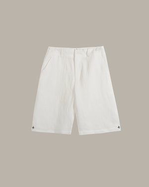 White shorts with a small black embroidered logo on each hem, displayed flat against a solid taupe background.