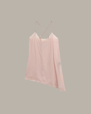 A light pink camisole top with thin double shoulder straps, shown against a solid taupe-gray background.