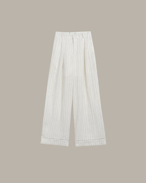 White pleated pants on a beige background