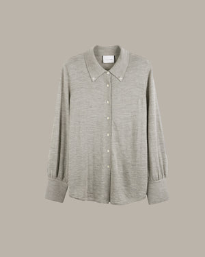 A light gray heathered long-sleeve button-up shirt with a pointed collar and decorative buttons, displayed against a solid taupe background.