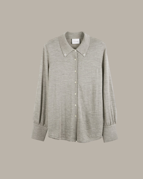 A light gray heathered long-sleeve button-up shirt with a pointed collar and decorative buttons, displayed against a solid taupe background.
