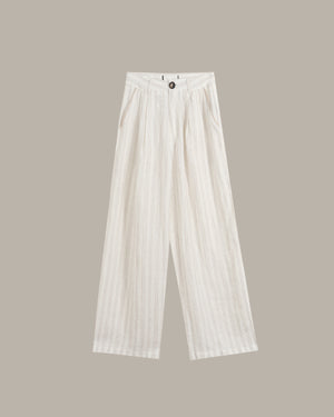 White wide-leg trousers with a subtle vertical textured stripe pattern, featuring a high-waisted design and front button closure, shown against a solid taupe background.