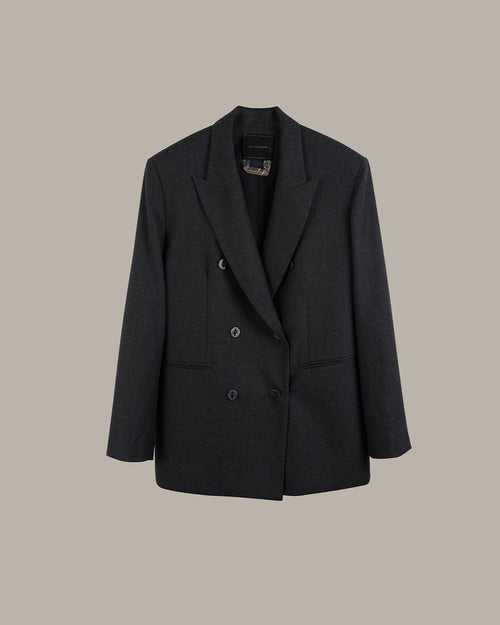 A dark charcoal gray double-breasted blazer with notched lapels and a subtle textured weave, displayed against a solid warm gray background.