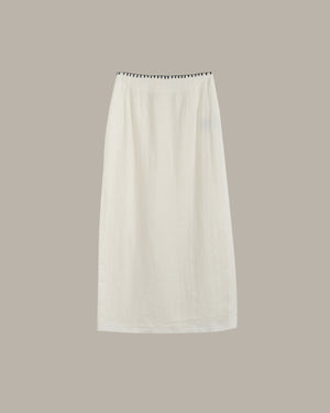 White skirt with black trim on a beige background