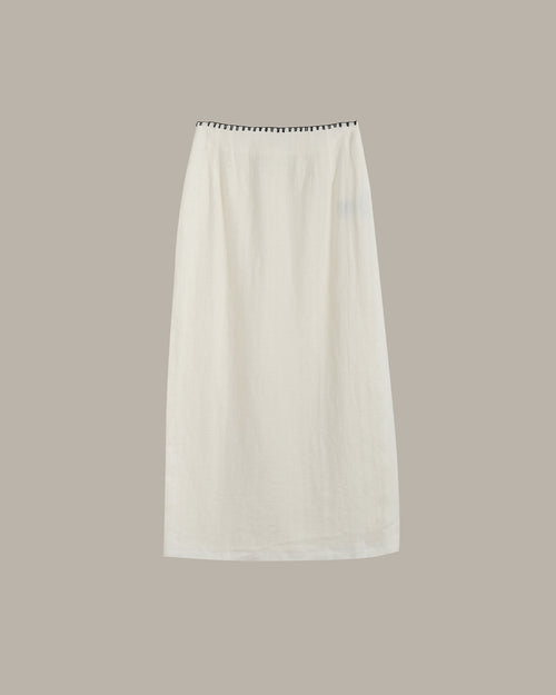 White skirt with black trim on a beige background