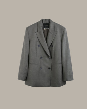 A gray double-breasted blazer with notched lapels and dark buttons, displayed against a solid beige background.