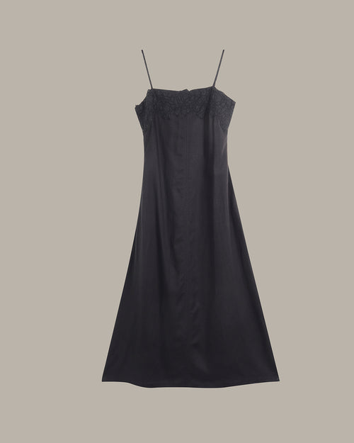 Black slip dress on a beige background