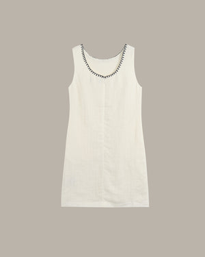 White sleeveless dress with decorative neckline on a beige background