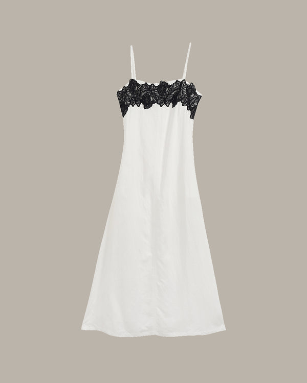White dress with black lace on a beige background