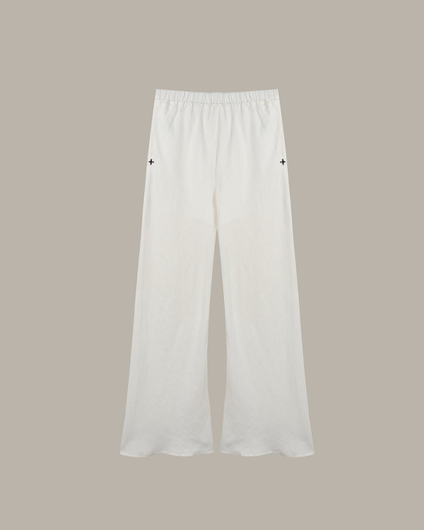White wide-leg cropped pants with an elastic waistband and small black embroidered star details on the upper thighs, shown against a solid taupe background.