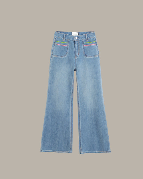 Light blue wide-leg denim jeans with colorful embroidered details on the front pockets, displayed flat against a solid taupe background.