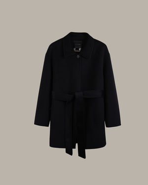 A black wool coat with a collar, single button closure, and a matching self-tie belt, displayed against a solid taupe background.