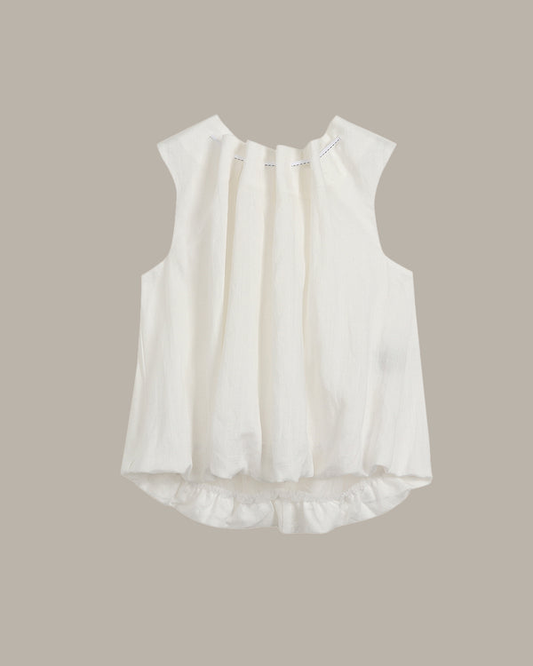 White sleeveless blouse with ruffled details on a beige background