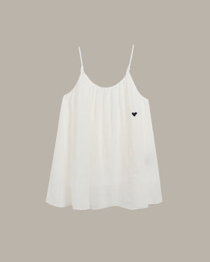 White cami with a black heart on a beige background