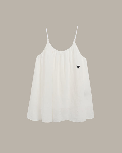 White cami with a black heart on a beige background