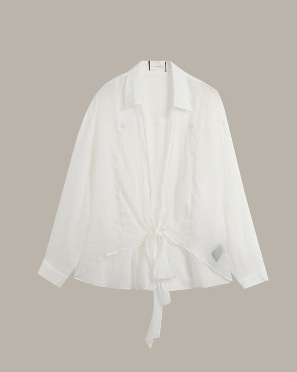 A white long-sleeve shirt with a collar and a front tie detail, displayed against a solid taupe background.
