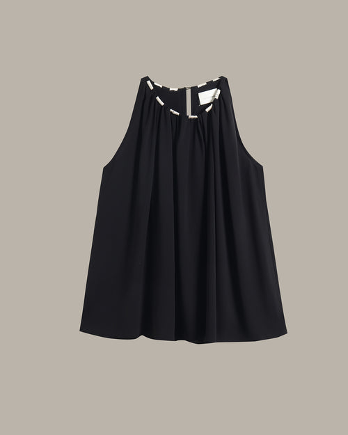 A black sleeveless top with a gathered, pleated front and a keyhole cutout at the neckline, shown flat against a solid taupe background.