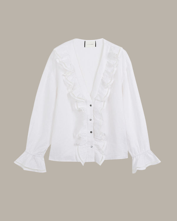 White ruffle blouse with ruffled details on a beige background