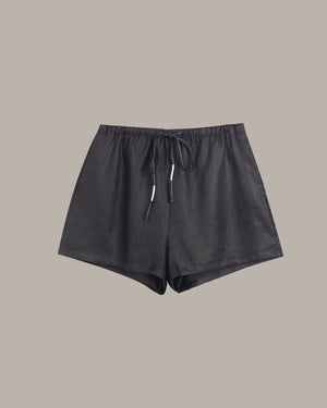 Black shorts with drawstring on a beige background