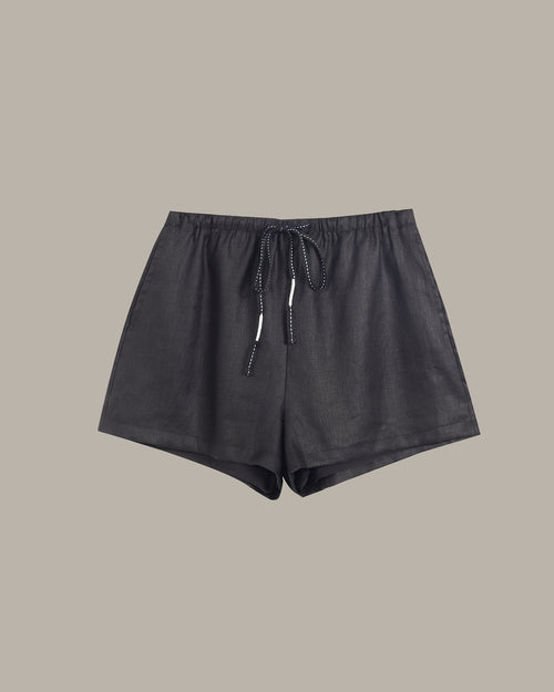 Black shorts with drawstring on a beige background
