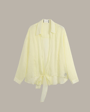 A pale yellow lightweight open-front cardigan with a collar, long sleeves, and a tie detail at the hem, displayed against a solid taupe background.