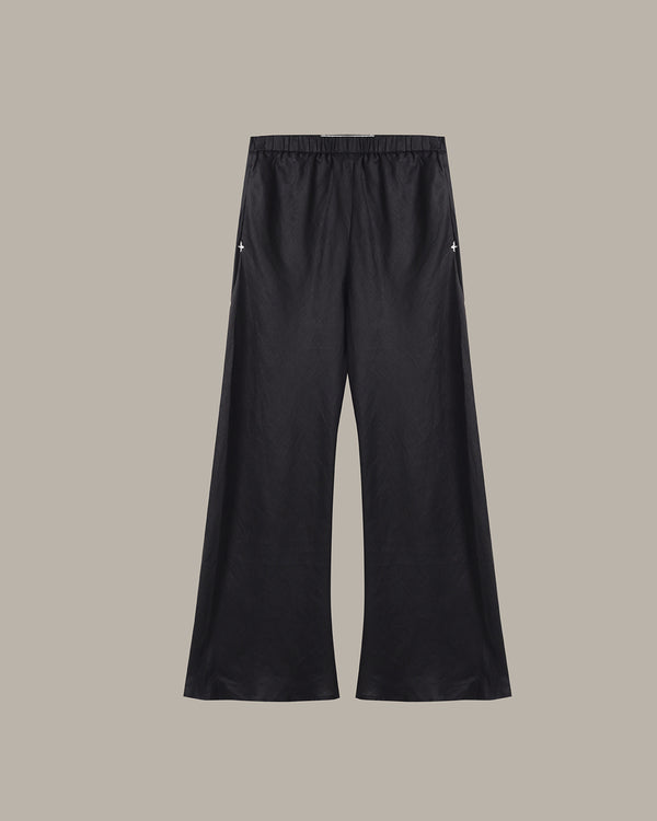 Black wide-leg cropped pants with an elastic waistband and small white embroidered star details on the upper thighs, shown against a solid taupe background.