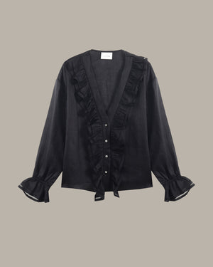 black ruffle blouse with ruffled details on a beige background