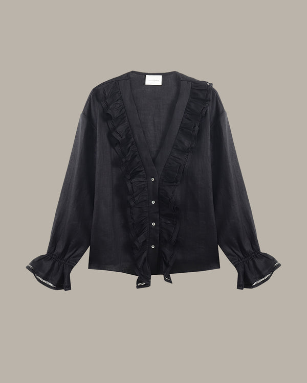 black ruffle blouse with ruffled details on a beige background