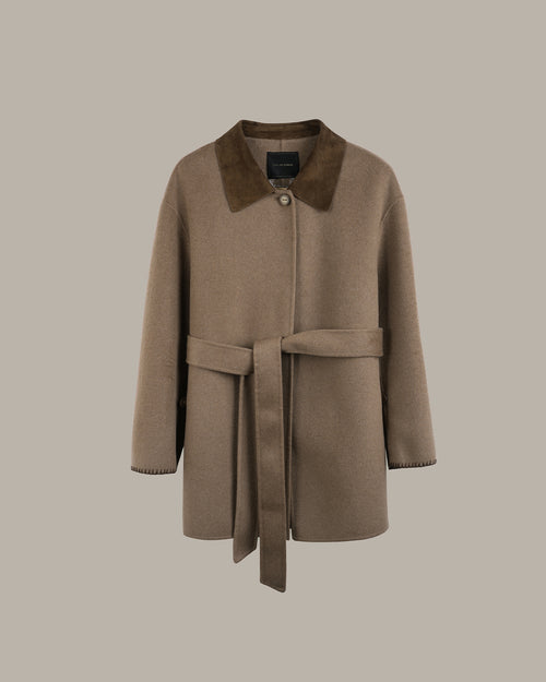 A taupe-brown wool coat with a contrasting dark brown suede collar and a matching waist tie belt, shown against a solid taupe background.