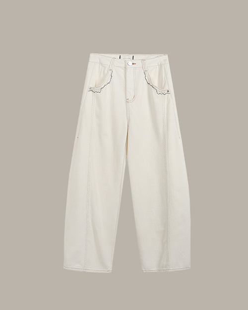 White jeans with lace details on a beige background