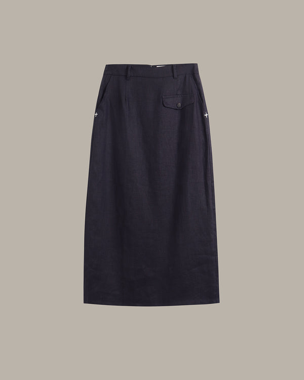A dark navy blue skirt with a single buttoned flap pocket on the right side, shown flat against a solid taupe background.