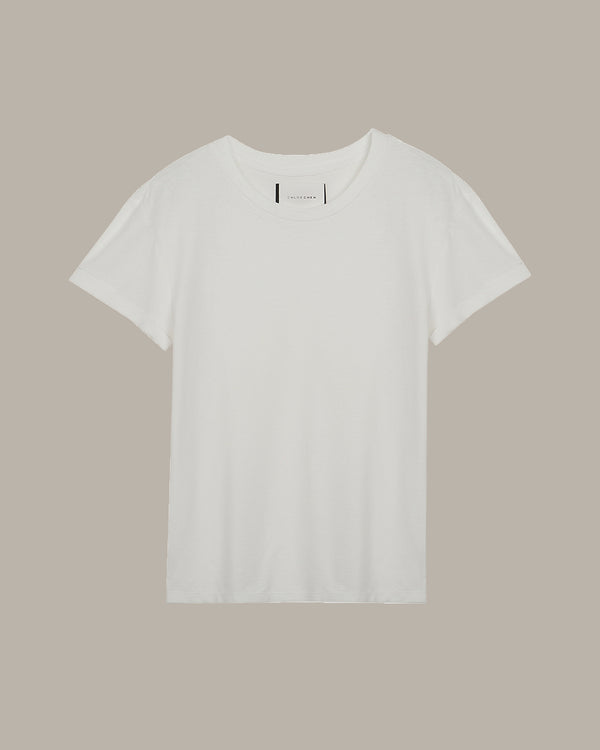 White cotton t-shirt with a minimalist crew neck design, featuring a small red embroidered heart detail on the back near the neckline, displayed on a beige background.