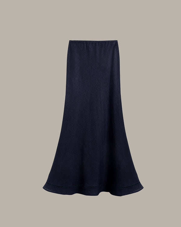 A dark navy blue midi skirt with a flared silhouette, displayed against a solid taupe-gray background.