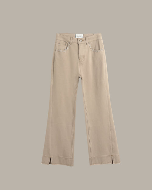 A pair of beige wide-leg cropped jeans with front slash hems, displayed flat against a solid taupe background.