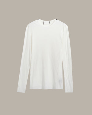 A plain white long-sleeve crewneck shirt displayed flat against a solid taupe-gray background.