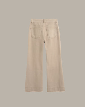 A pair of light beige wide-leg jeans shown from the back, featuring two back pockets and a button closure, set against a solid taupe-gray background.