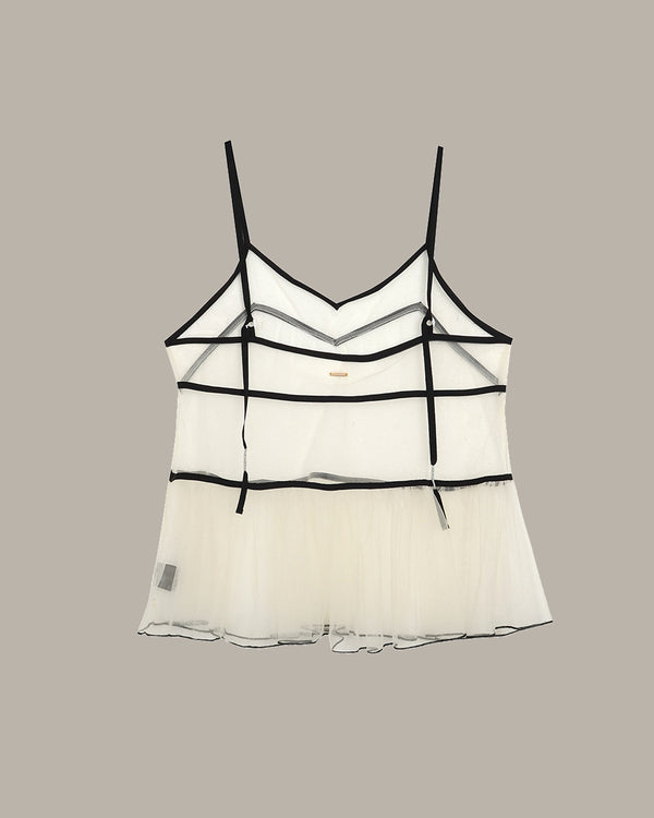 White lace camisole with thin black straps on a beige background