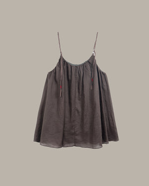 Brown slip dress with thin straps on a beige background