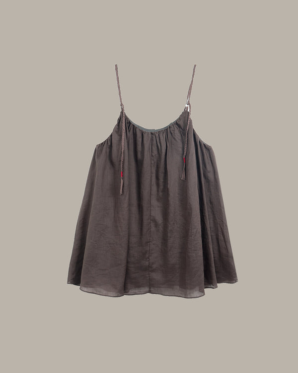 Brown slip dress with thin straps on a beige background