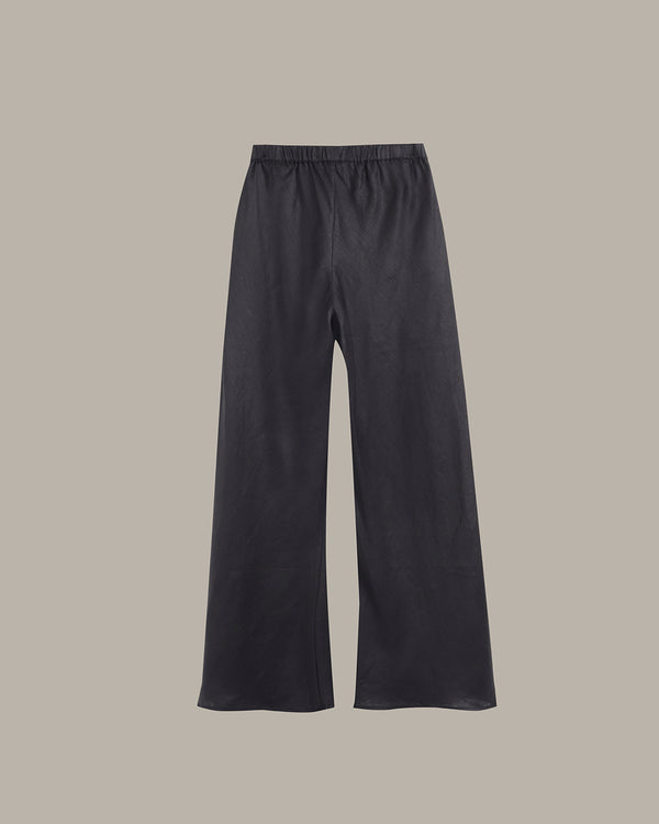A pair of dark charcoal gray wide-leg pants with an elastic waistband, shown flat against a solid taupe background.