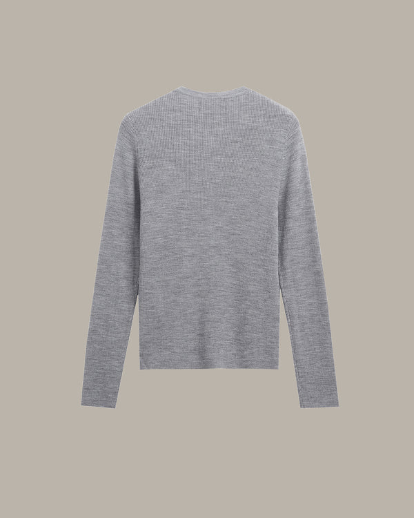 A light gray long-sleeve knit sweater shown from the back, centered on a solid warm beige background.