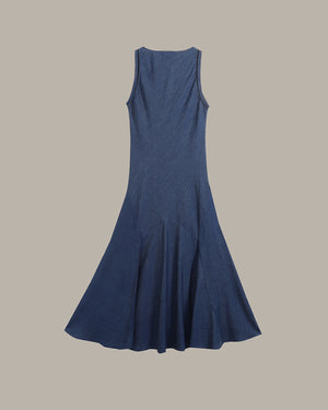A sleeveless, A-line midi dress in a textured slate blue fabric, shown from the back against a solid taupe background.