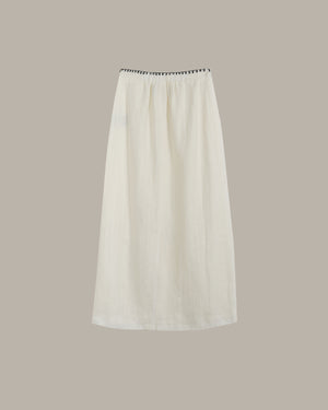 White skirt with black trim on a beige background