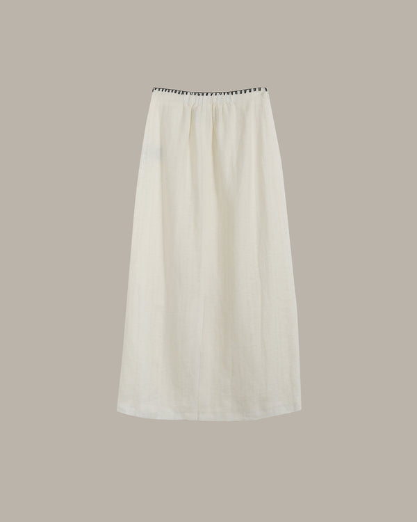 White skirt with black trim on a beige background